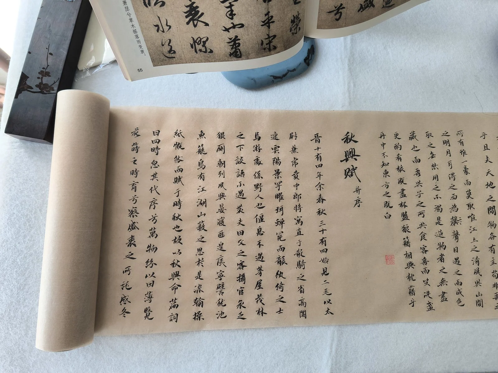 写完的《赤壁赋》长卷,与摊开的《秋兴赋》字帖